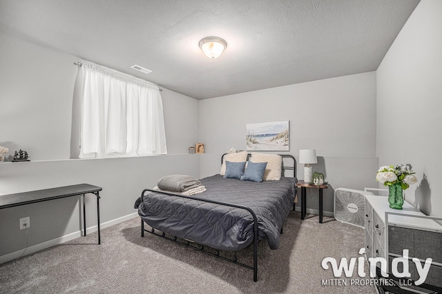 bedroom with a textured ceiling, carpet flooring, visible vents, and baseboards