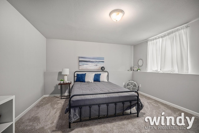 carpeted bedroom featuring a textured ceiling and baseboards