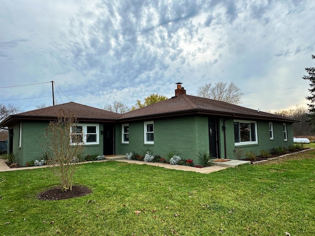 ranch-style house with brick siding, a front lawn, and a chimney