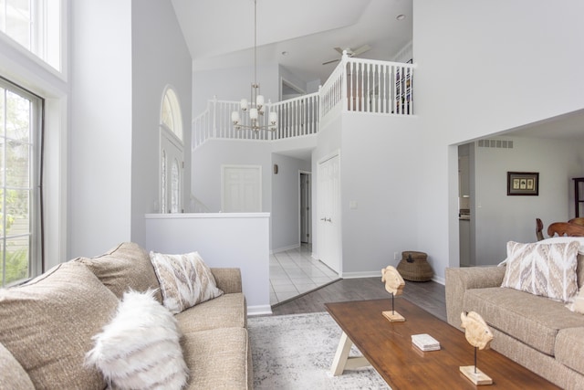 living area with baseboards, visible vents, a chandelier, and wood finished floors