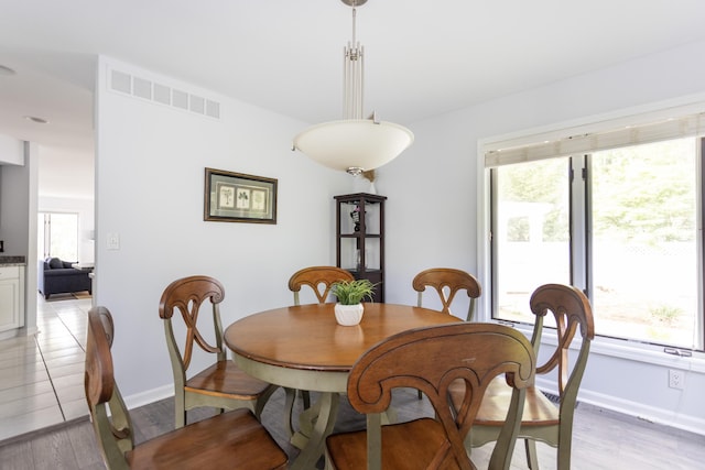 dining room with a healthy amount of sunlight, visible vents, and light wood-style flooring