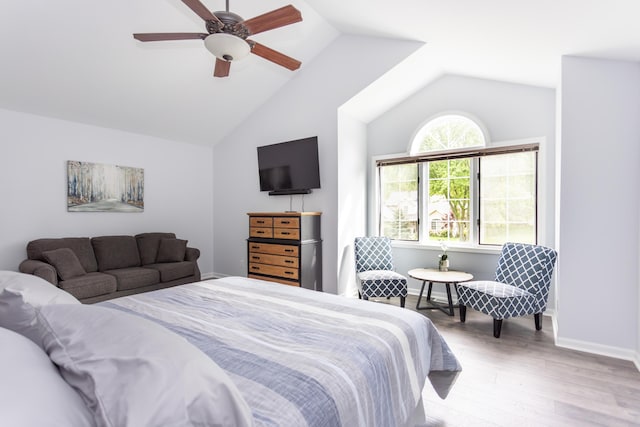 bedroom with a ceiling fan, lofted ceiling, baseboards, and wood finished floors
