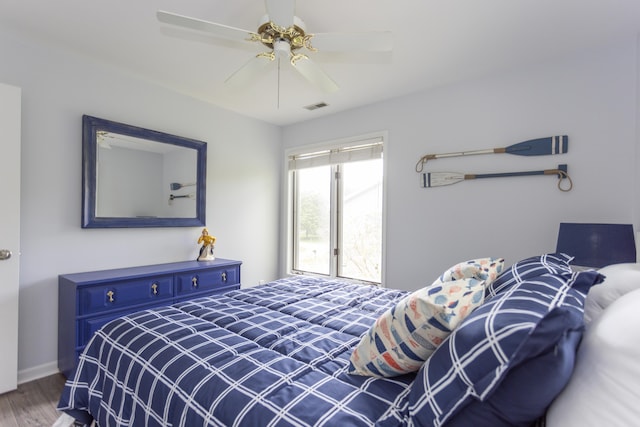 bedroom featuring ceiling fan, wood finished floors, visible vents, and baseboards
