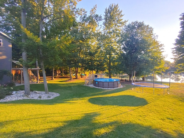 exterior space featuring playground community, a trampoline, and an outdoor pool