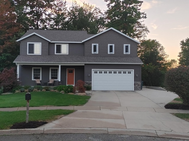 view of front facade featuring driveway, a porch, roof with shingles, an attached garage, and a front lawn