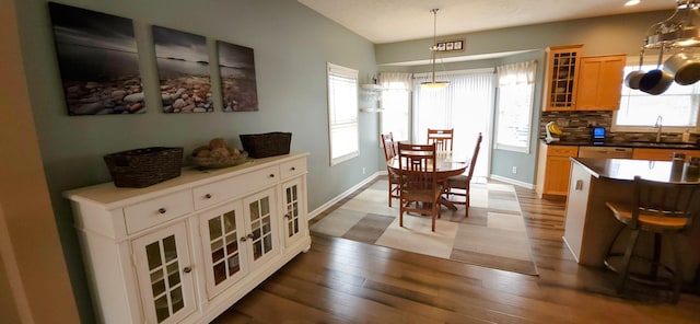 dining area with baseboards and wood finished floors