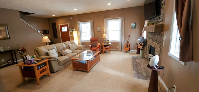 living room featuring a textured ceiling, recessed lighting, light colored carpet, a fireplace, and baseboards