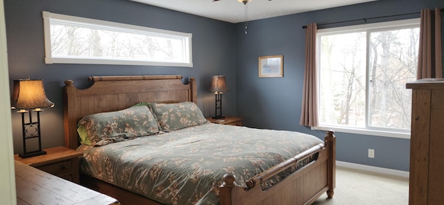 bedroom with carpet floors, multiple windows, and baseboards