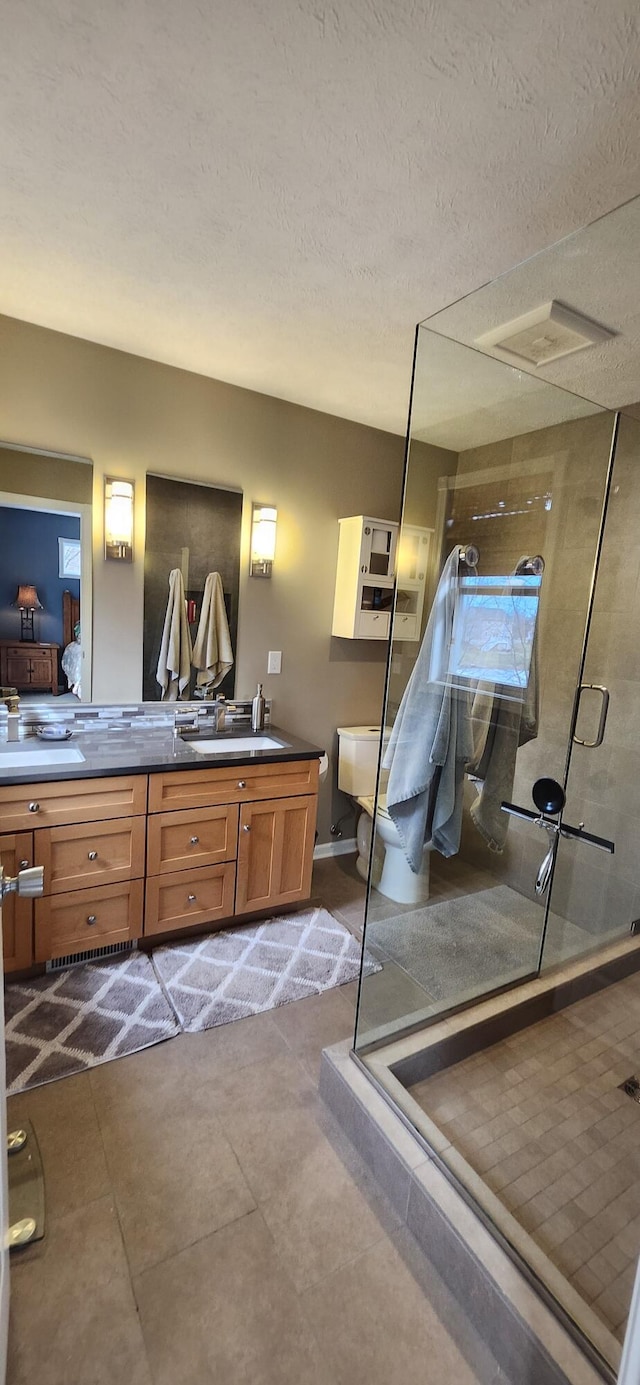 full bath featuring visible vents, vanity, a shower stall, a textured ceiling, and tile patterned flooring