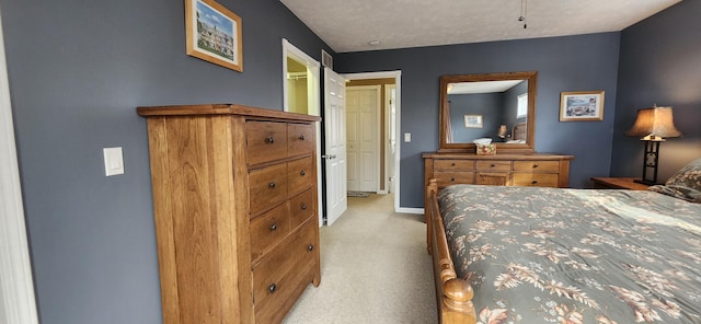 bedroom featuring baseboards, a textured ceiling, and light colored carpet