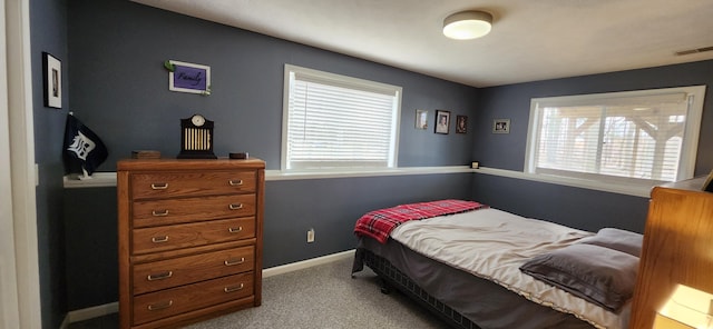 carpeted bedroom with baseboards, multiple windows, and visible vents