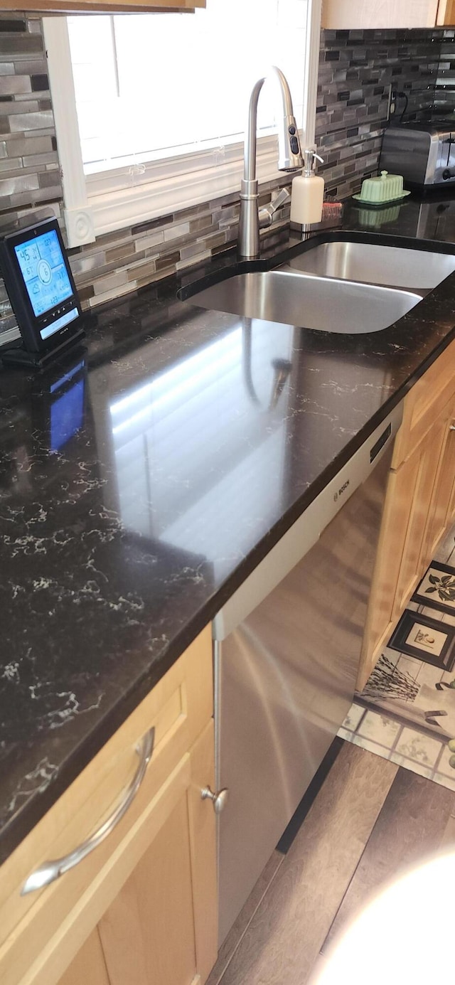 kitchen with dishwasher, a sink, and decorative backsplash