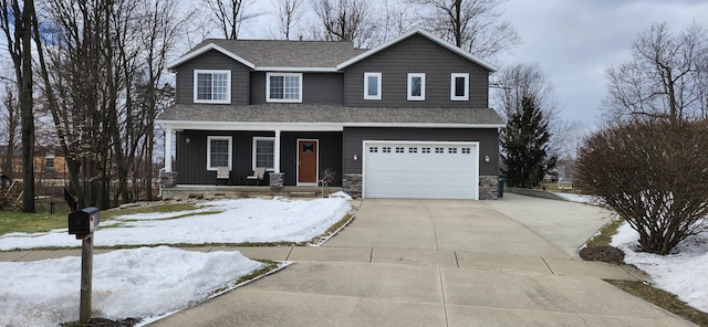 view of front of property with a shingled roof, concrete driveway, covered porch, board and batten siding, and stone siding