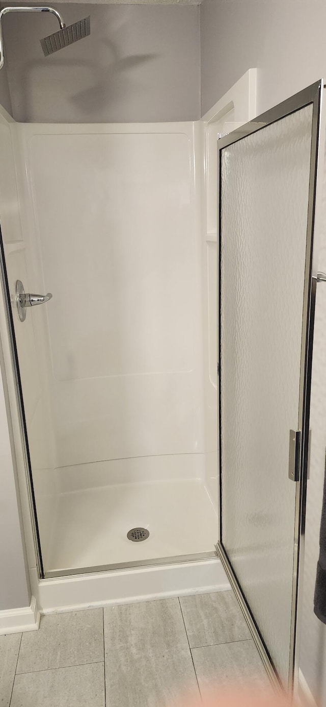 bathroom with a stall shower and tile patterned flooring