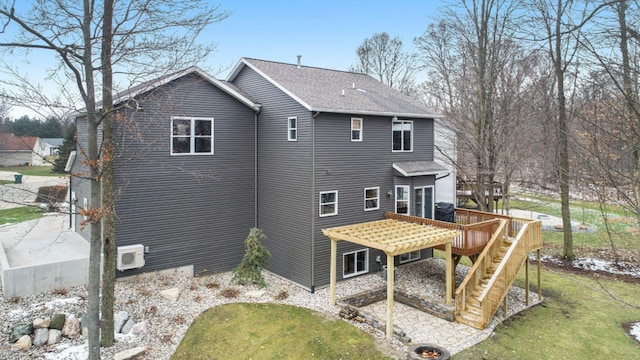 rear view of house with roof with shingles, stairs, and a wooden deck