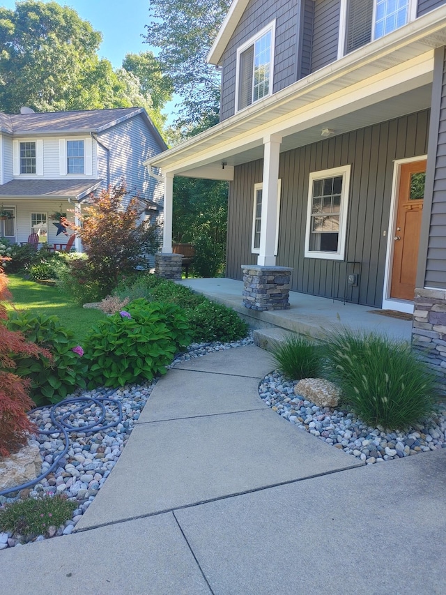 view of exterior entry featuring board and batten siding and covered porch