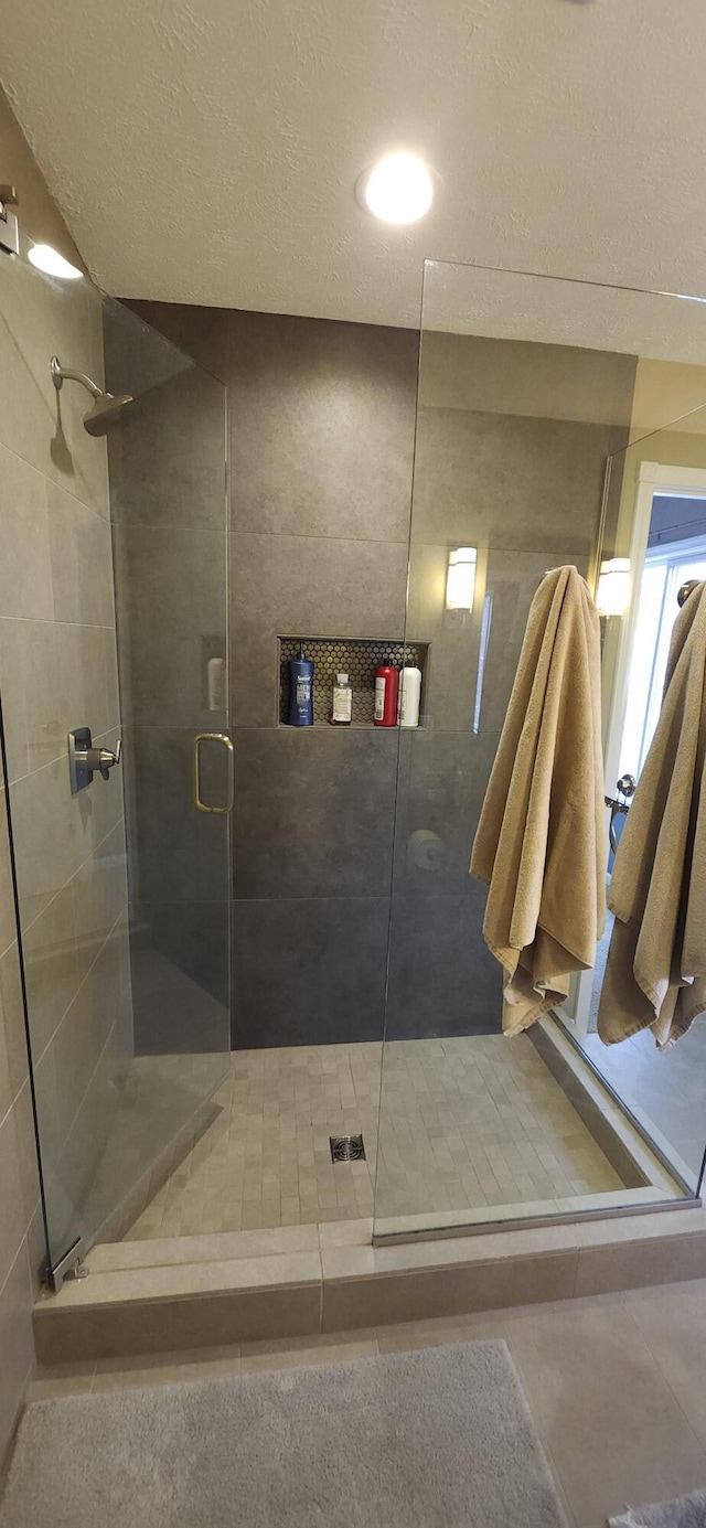 full bath featuring a stall shower and tile patterned flooring