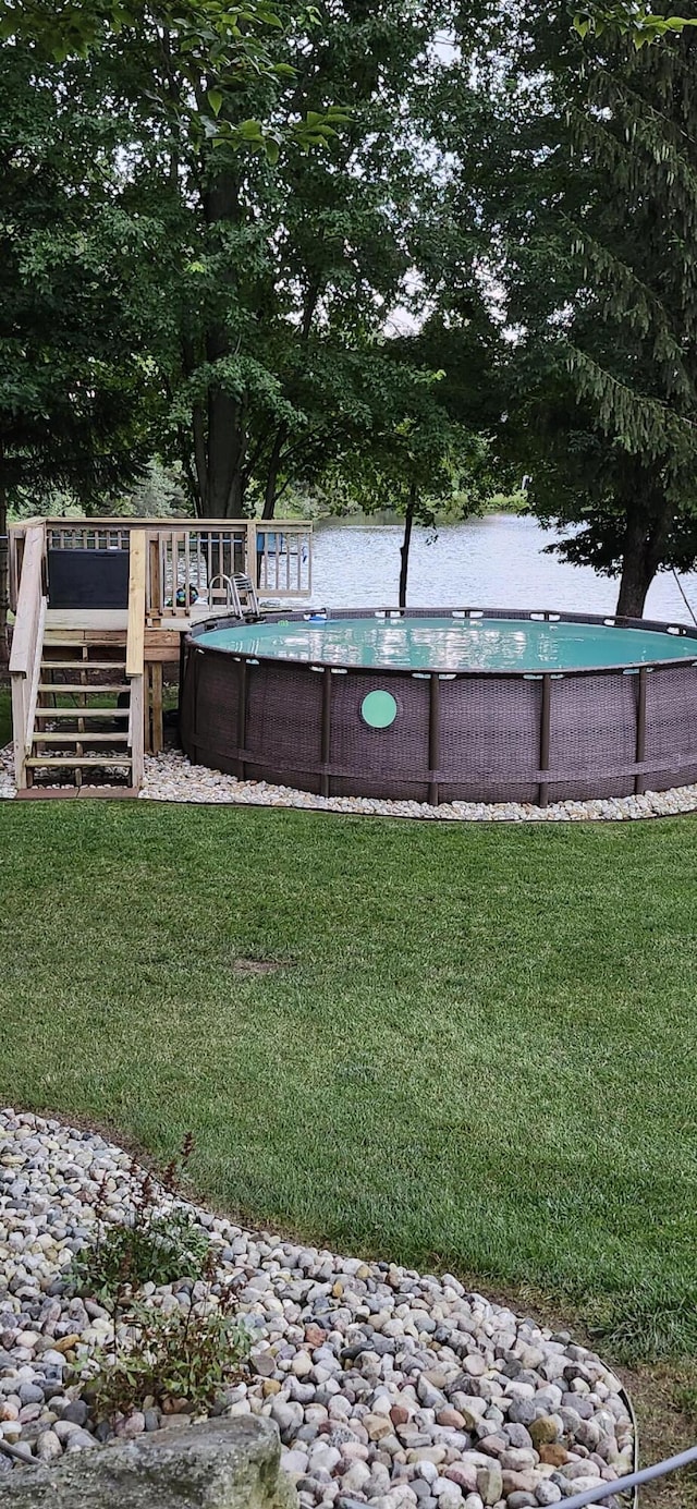 view of yard featuring a deck, stairway, and an outdoor pool