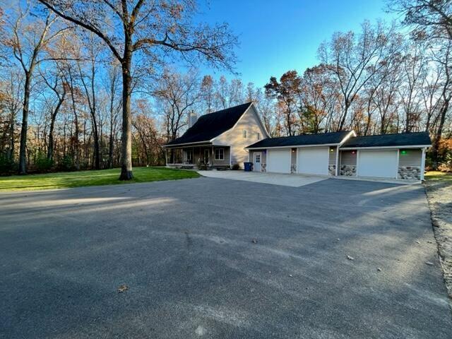 view of front of property featuring driveway, an attached garage, and a front yard