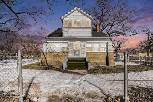 view of front of home featuring entry steps, stone siding, a chimney, and fence