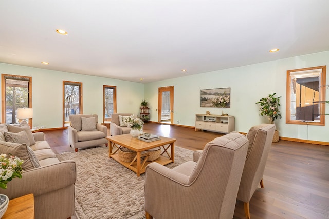 living room with baseboards, wood finished floors, and recessed lighting