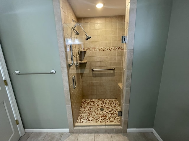 bathroom with a stall shower and baseboards