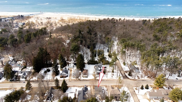 birds eye view of property with a water view and a beach view