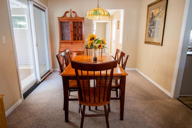 carpeted dining space with plenty of natural light and baseboards