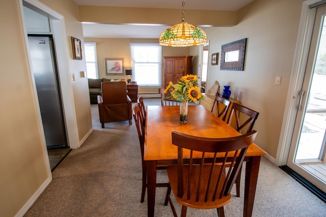 carpeted dining room featuring baseboard heating and baseboards