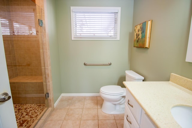 full bath featuring toilet, vanity, baseboards, tile patterned floors, and a stall shower