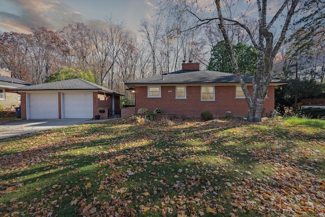 view of front facade featuring an outbuilding, brick siding, a chimney, and a detached garage