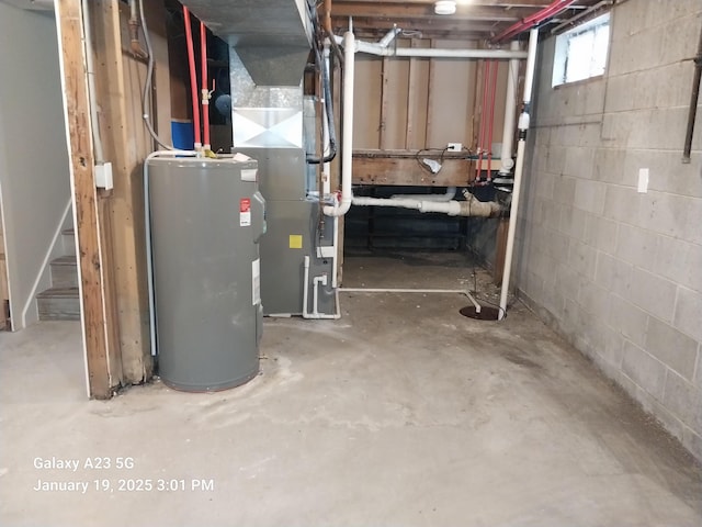 basement with concrete block wall, electric water heater, stairway, and heating unit