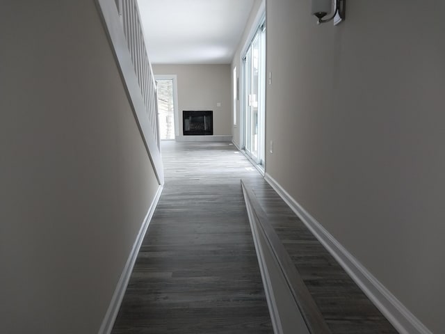 hall featuring dark wood-style floors and baseboards