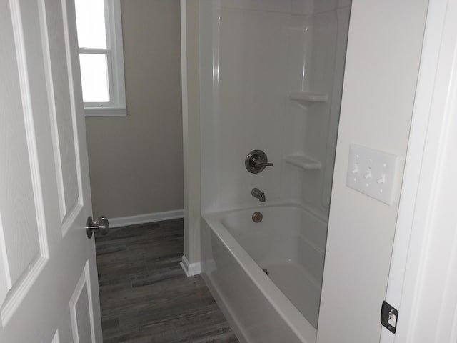 full bathroom with shower / bathing tub combination, baseboards, and wood finished floors