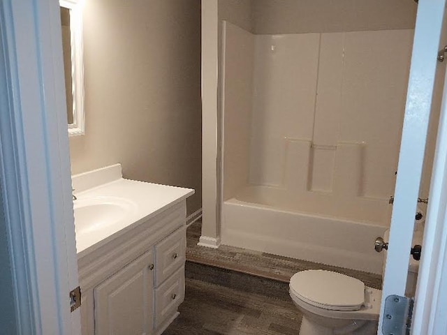 full bath with toilet, shower / washtub combination, wood finished floors, and vanity