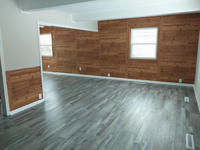 unfurnished room with plenty of natural light, visible vents, and wood finished floors