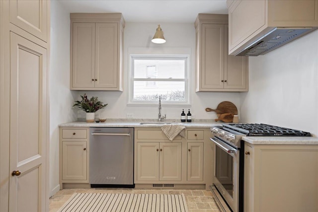 kitchen with stainless steel appliances, cream cabinets, a sink, and light countertops