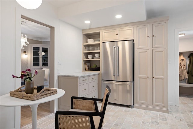 kitchen featuring open shelves, high quality fridge, light stone counters, and recessed lighting