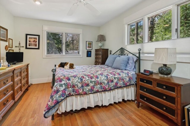 bedroom with ceiling fan, light wood finished floors, and baseboards