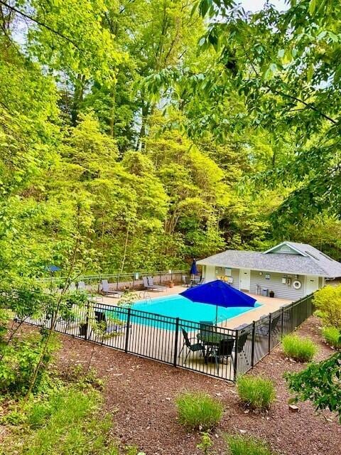 pool with a patio and fence