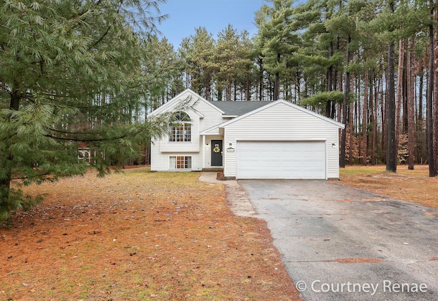 split level home featuring aphalt driveway and an attached garage