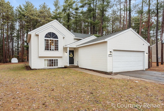 tri-level home with a garage, aphalt driveway, and a front lawn