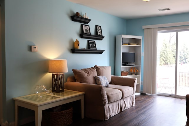 living area with visible vents and wood finished floors