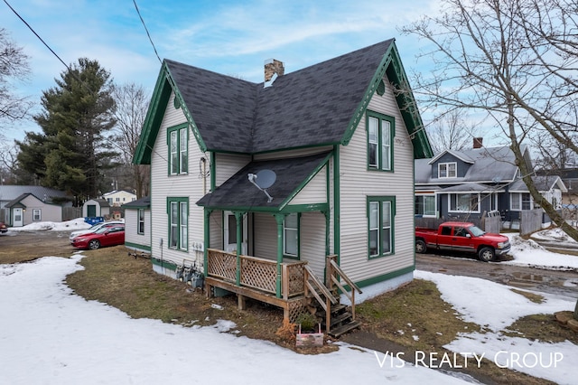 view of front of property with covered porch, a chimney, and roof with shingles