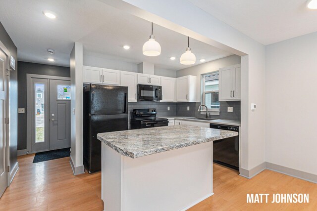 2105 Willard Ave SE, Grand Rapids, MI 49507 - kitchen featuring light wood-style floors, white cabinetry, black appliances, and tasteful backsplash