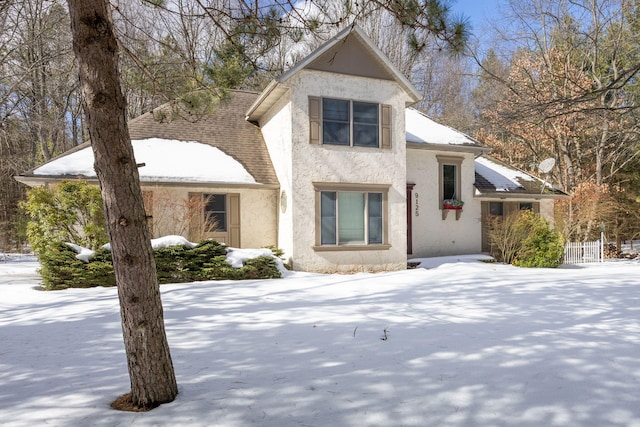 view of front facade featuring a shingled roof and stucco siding