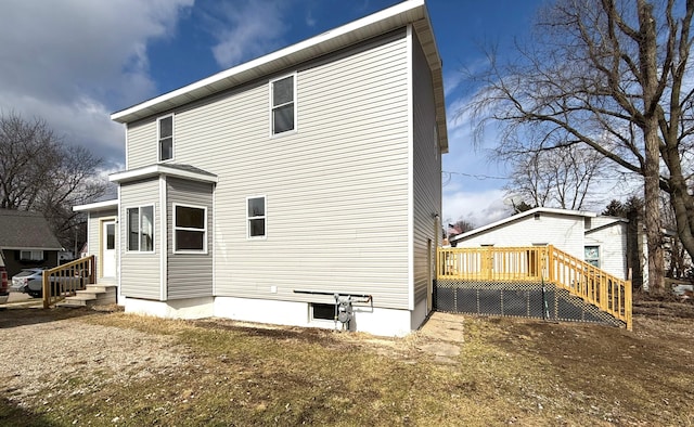 rear view of house featuring entry steps and a wooden deck