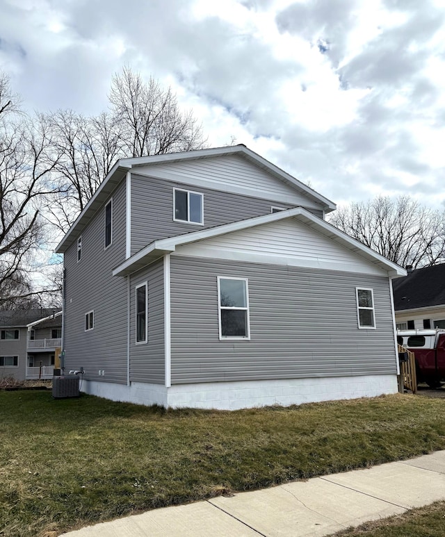 view of side of home featuring central air condition unit and a lawn