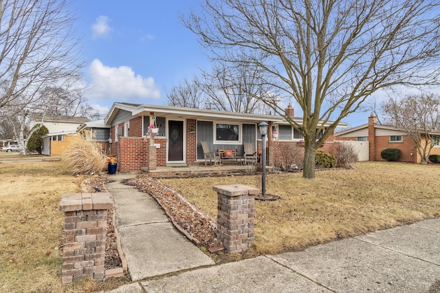 single story home with brick siding, covered porch, a chimney, and fence