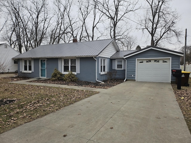 ranch-style home featuring concrete driveway, metal roof, a chimney, and an attached garage